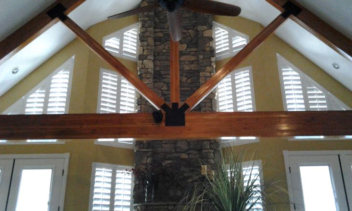 Angled windows on tan wall with limestone divider.